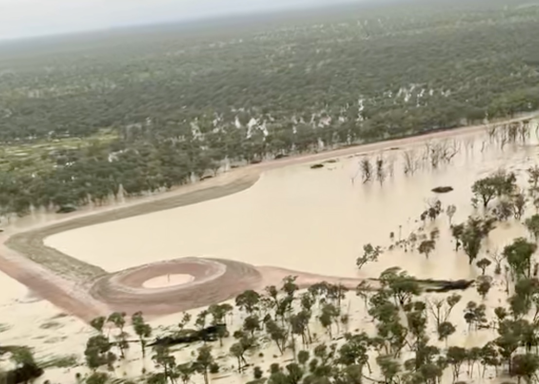 Aerial of completed dam and water infrastructure holding water after wet season in Queensland
