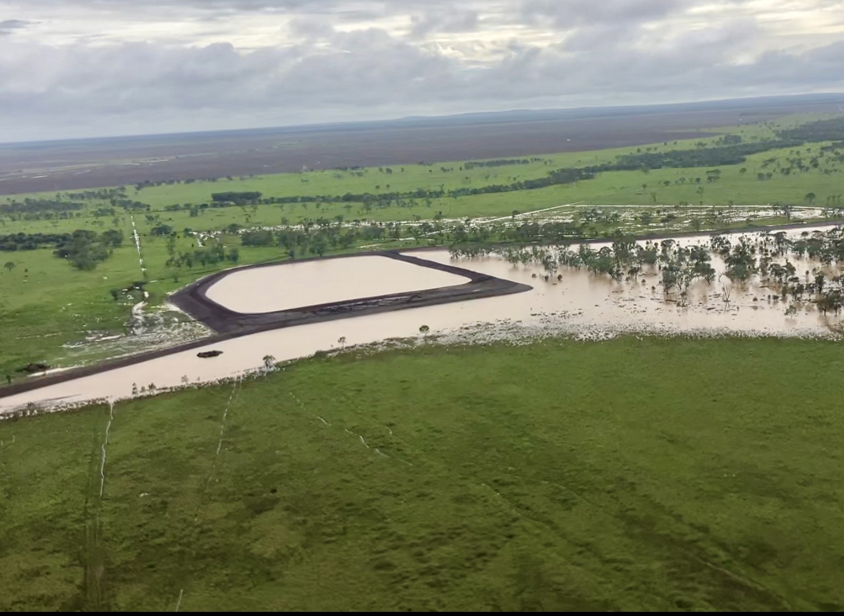 Aerial of dam at capacity surrounded by green pasture on a Queensland agricultural property