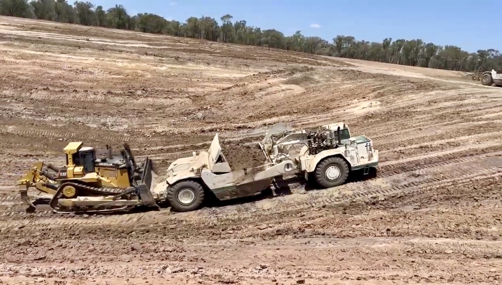 CAT dozer pushing scraper on a dam construction site near Clermont, Queensland